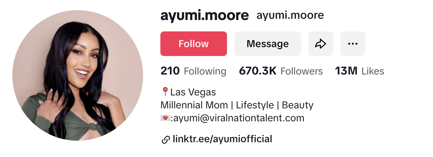 Ayumi poses of rhte camera with a big smile and both hands resting on her shoulders